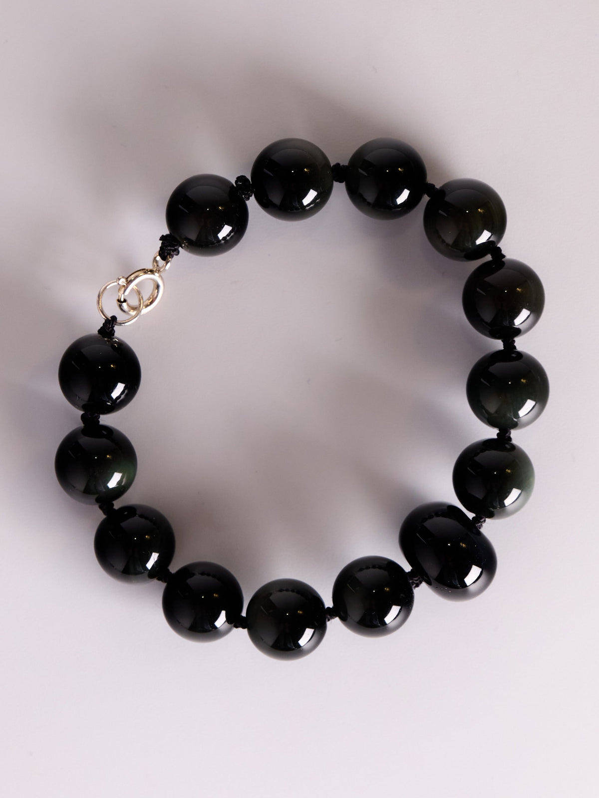 Black Aurora Bracelet, close-up of rainbow obsidian beads on black silk