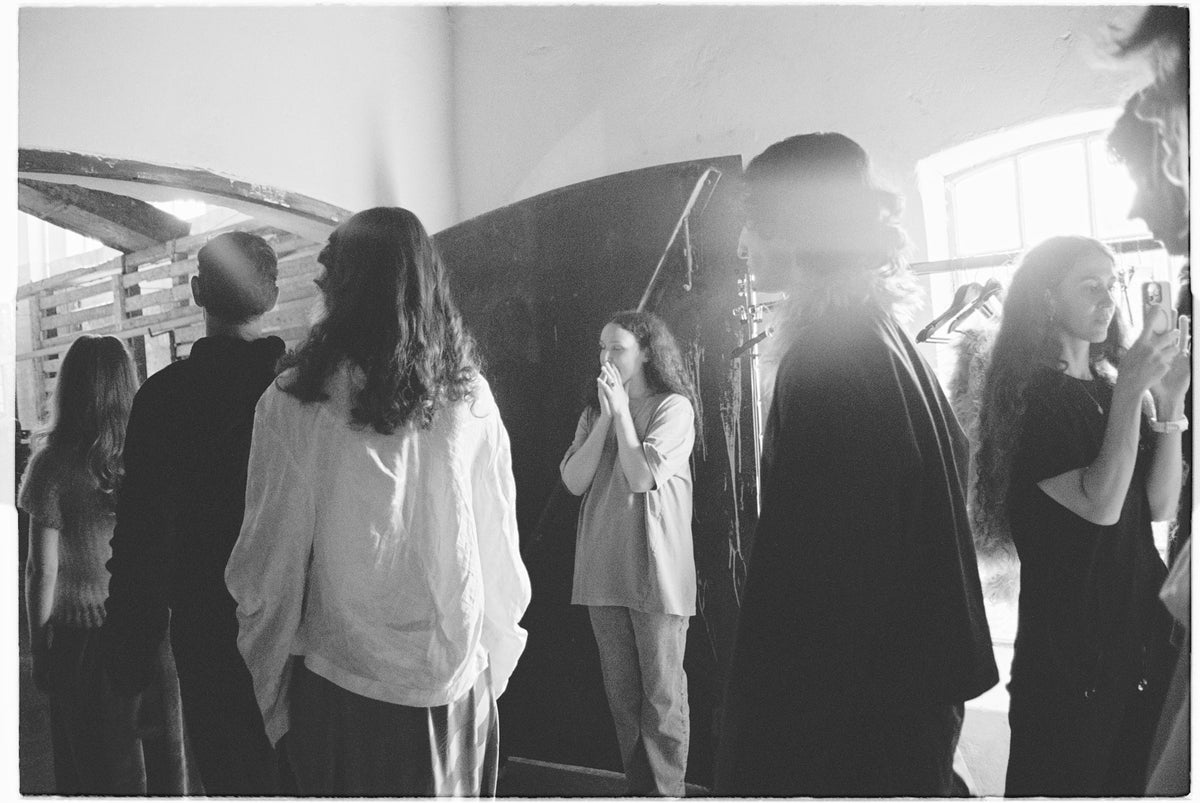 Black and white backstage photo with models and crew